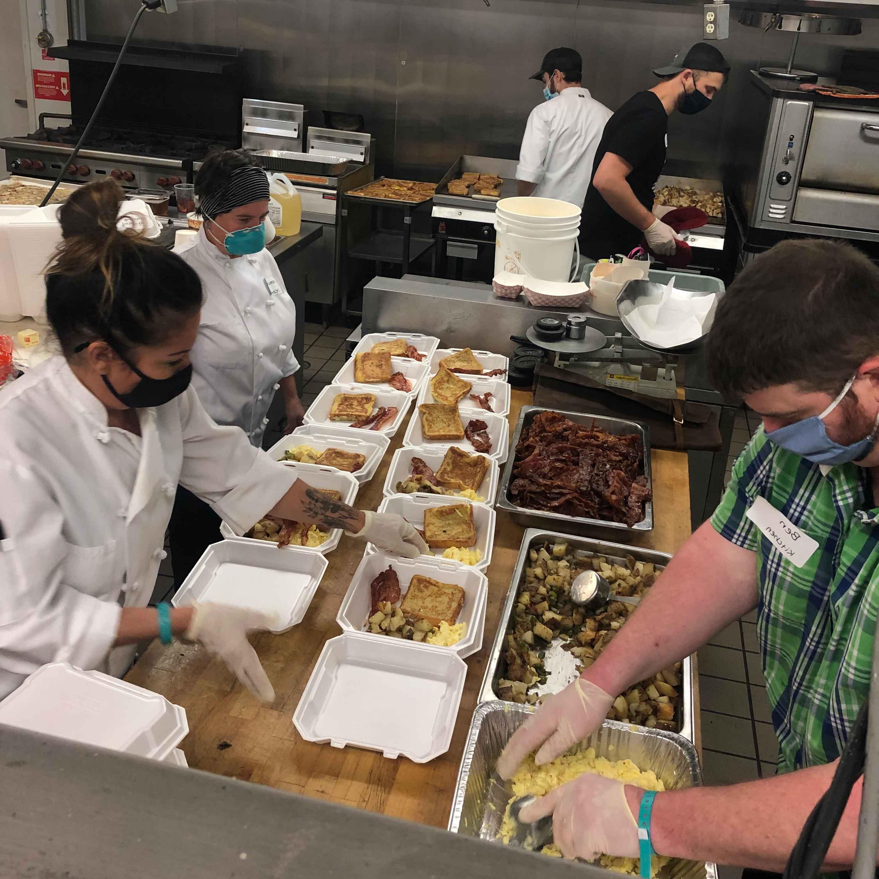 Culinary students in kitchen boxing food